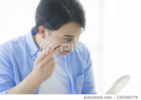 Man grooming his eyebrows 130308779