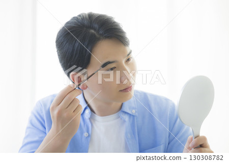 Man grooming his eyebrows 130308782