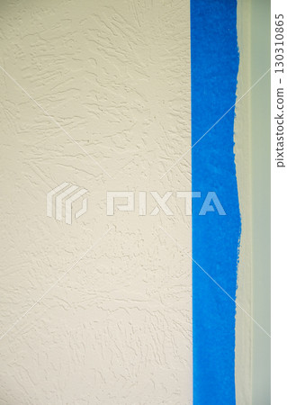 Wall preparation for painting in a room with blue masking tape along textured surface Wall preparation for painting in a room with blue masking tape along textured surface 130310865