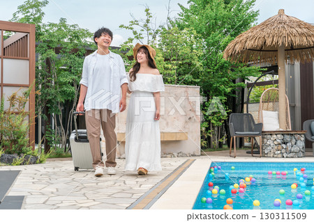 Young Asian couple walking by the poolside of a resort hotel (travel, honeymoon, vacation) 130311509