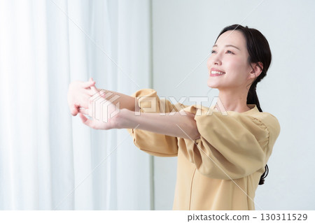 A woman stretching in the sunlight 130311529