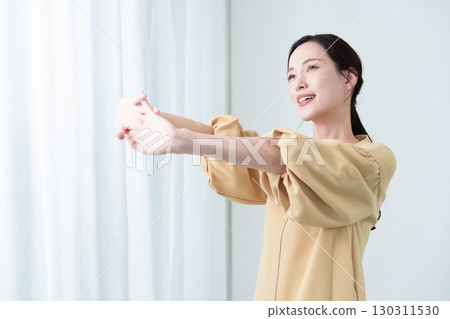 A woman stretching in the sunlight 130311530