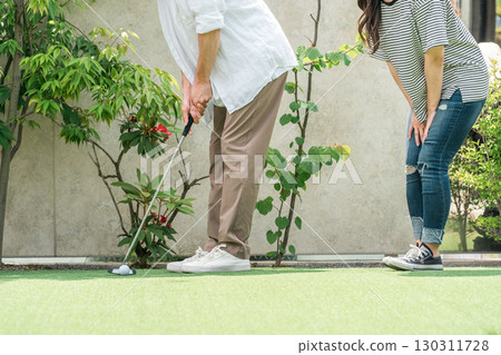 Couple playing putt-putt golf 130311728