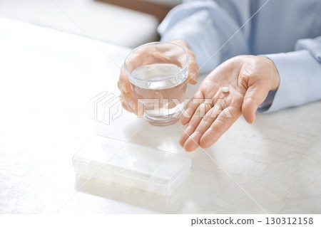 一位中年婦女吃藥的手 一位中年婦女吃藥的手 130312158