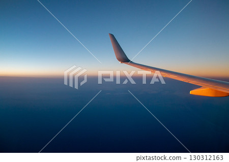 從飛機窗戶看到的日落、海、天空和機翼 130312163