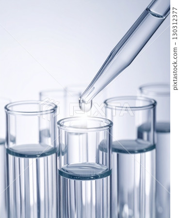 Close-up of pipette dropping liquid into test tube 130312377