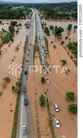 Aerial view of car driving on the road flooded after Kok river rising during heavy rain in Chiang Rai province, Thailand. 130312600
