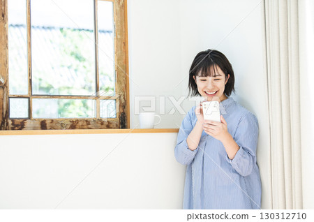 Young woman searching on her smartphone Young woman searching on her smartphone 130312710