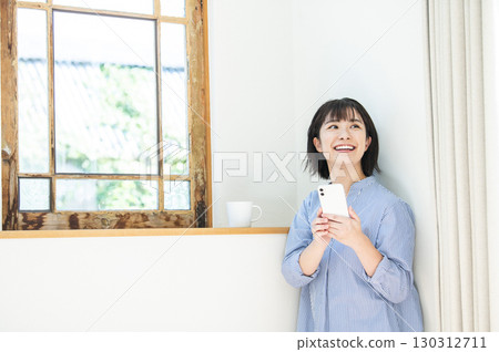 Young woman searching on her smartphone 130312711