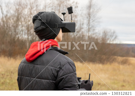 Young man launches rc plane into sky. Teenager with glasses playing with toy radio-controlled airplane outdoors. Boy holding radio remote controller. High quality photo Young man launches rc plane into sky. Teenager with glasses playing with toy radio-controlled airplane outdoors. Boy holding radio remote controller. High quality photo 130312821