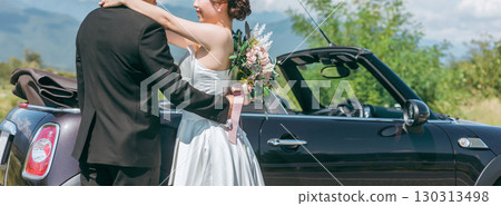 Bride and groom taking wedding photos with their beloved car (convertible) 130313498