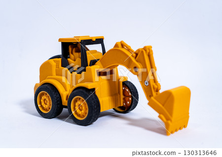 Yellow toy excavator resting on white background Yellow toy excavator resting on white background 130313646