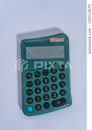 Green pocket calculator lying on white background 130313670