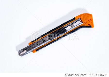 Orange and black utility knife on white background Orange and black utility knife on white background 130313673