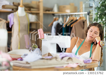 woman dressmaker sits tired at the table 130313762