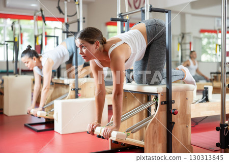 Young woman doing exercises on pilates machine 130313845