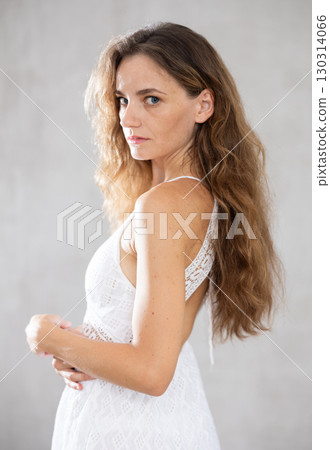 Portrait of middle aged woman smiling looking at camera over grey background Portrait of middle aged woman smiling looking at camera over grey background 130314066