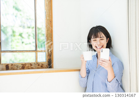 智慧型手機微笑的年輕女人 智慧型手機微笑的年輕女人 130314167