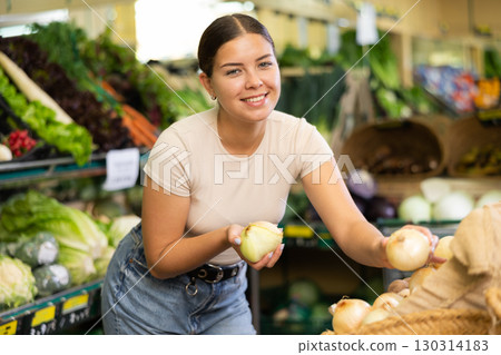 Portrait of female customer selecting onion in supermarket Portrait of female customer selecting onion in supermarket 130314183