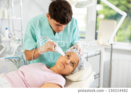 dermatologist deftly wields skin scrubber 130314482