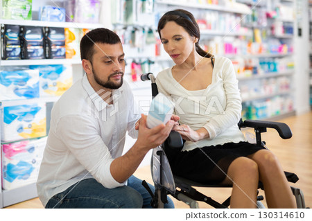 Woman in wheelchair and man in drugstore 130314610