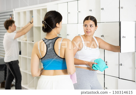 Two young women talking near lockers in locker room Two young women talking near lockers in locker room 130314615
