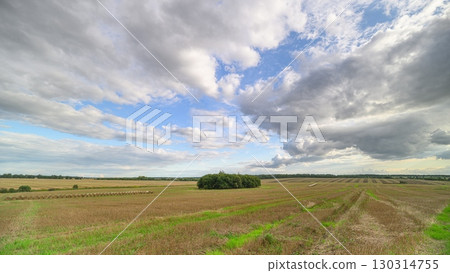 Experience a Scenic Panoramic View of Expansive Open Farmland Set Against Dramatic Clouds 130314755