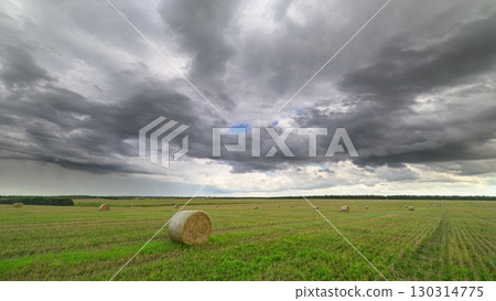 A Dramatic and Beautiful Cloudy Sky Over Expansive Green Fields in the Countryside 130314775