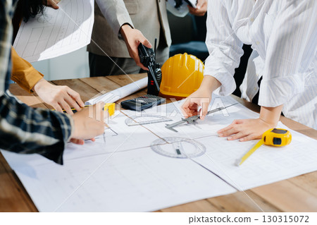 Engineer Teamwork Meeting, Drawing working on blueprint meeting for project working with partner on model building Engineer Teamwork Meeting, Drawing working on blueprint meeting for project working with partner on model building 130315072