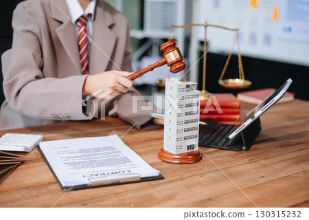 Real Estate Lawyer And House Foreclosure Law. House model, hammer judge gavel on table with white background. 130315232