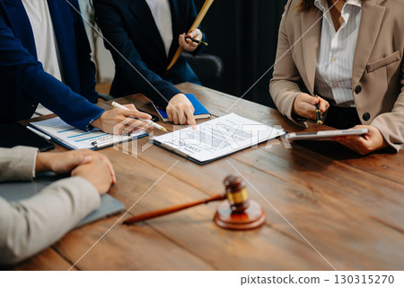 Business and lawyers discussing contract papers with brass scale on desk in office. Law, legal services, advice, justice and law Business and lawyers discussing contract papers with brass scale on desk in office. Law, legal services, advice, justice and law 130315270