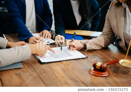 Business and lawyers discussing contract papers with brass scale on desk in office. Law, legal services, advice,  justice and law 130315273