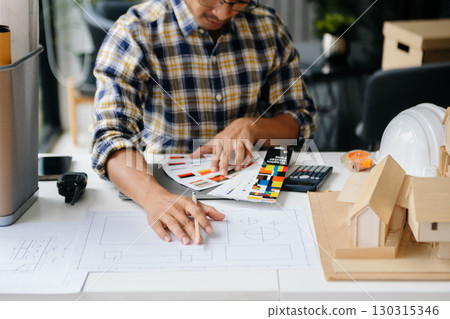 business man hand working and laptop with on on architectural project at construction site at desk business man hand working and laptop with on on architectural project at construction site at desk 130315346