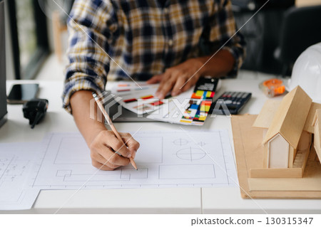 business man hand working and laptop with on on architectural project at construction site at desk business man hand working and laptop with on on architectural project at construction site at desk 130315347