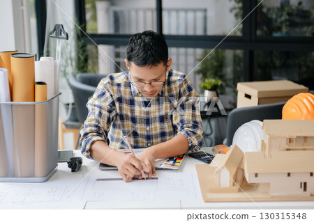 business man hand working and laptop with on on architectural project at construction site at desk business man hand working and laptop with on on architectural project at construction site at desk 130315348