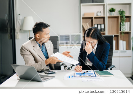 Furious two Asian businesspeople arguing strongly after making a mistake at work in modern office Furious two Asian businesspeople arguing strongly after making a mistake at work in modern office 130315614