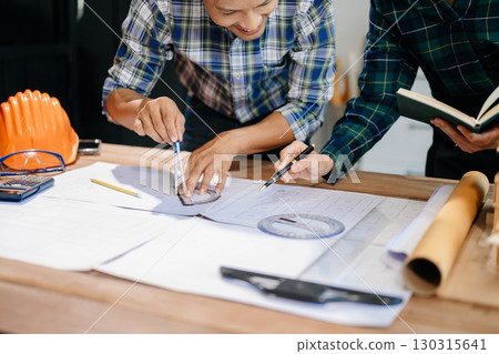 Engineer desk with object paper and tablet with blurry engineer teamwork hardworking to consults about their building project. 130315641