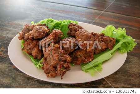 spicy pork cakes on dish in food shop 130315745