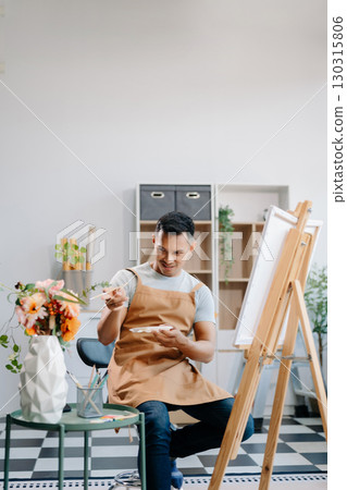 Asian male painter do artwork in art workshop, painting supplies, oil pastels, two canvas easel, creative space with paintbrush Asian male painter do artwork in art workshop, painting supplies, oil pastels, two canvas easel, creative space with paintbrush 130315806