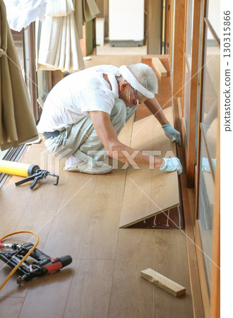 A carpenter is attaching boards to a piece of glued wood A carpenter is attaching boards to a piece of glued wood 130315866