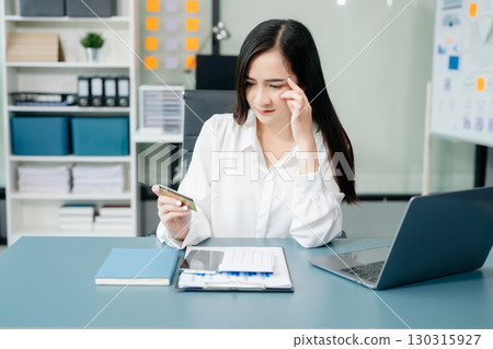 Financial owe, hand of asian woman sitting, holding credit card, stressed by calculate expense from invoice or bill, no money to pay, mortgage or loan. Financial owe, hand of asian woman sitting, holding credit card, stressed by calculate expense from invoice or bill, no money to pay, mortgage or loan. 130315927
