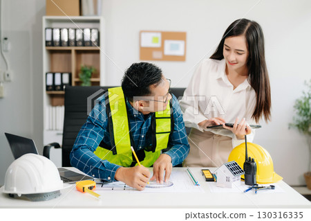 Engineer Teamwork Meeting, Drawing working on blueprint meeting for project working with partner on model building at company office Engineer Teamwork Meeting, Drawing working on blueprint meeting for project working with partner on model building at company office 130316335