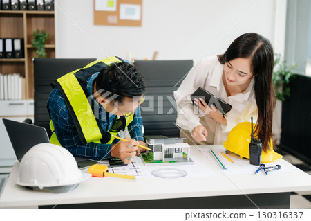 Engineer Teamwork Meeting, Drawing working on blueprint meeting for project working with partner on model building at company office 130316337