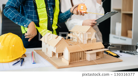 Creative architect projecting on the big drawings with architectural project at construction site at desk 130316377