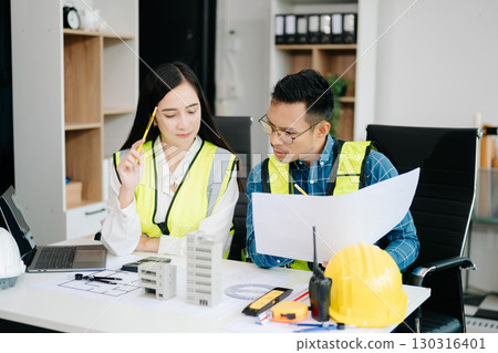 Creative architect projecting on the big drawings with architectural project at construction site at desk 130316401