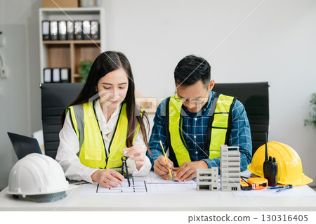 Creative architect projecting on the big drawings with architectural project at construction site at desk Creative architect projecting on the big drawings with architectural project at construction site at desk 130316405
