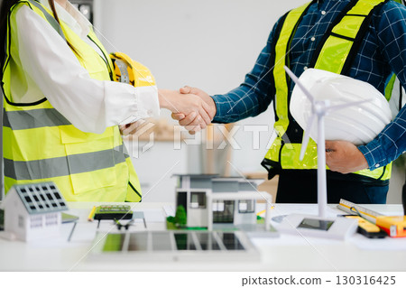 Engineer and contractor join hands after signing contract,They are having a modern building project together. Engineer and contractor join hands after signing contract,They are having a modern building project together. 130316425