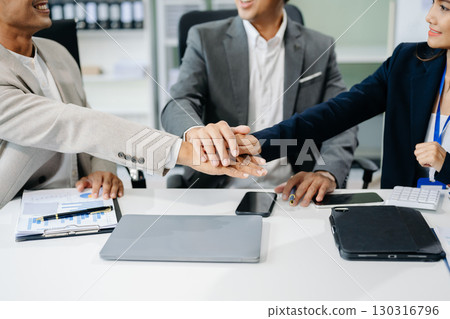 Teamwork business concept of group of three coworkers join hand together during their meeting. 130316796