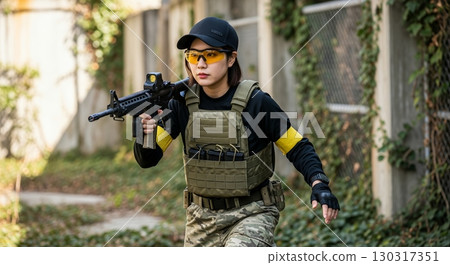 A young woman playing airsoft 130317351