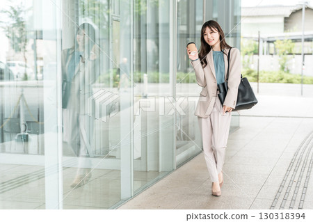 年輕的亞洲女商人在城市的辦公區散步 130318394